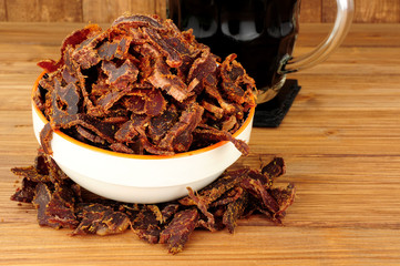 Bowl of shredded biltong meat on a wooden background