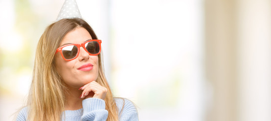 Young woman celebrates birthday thinking and looking up expressing doubt and wonder