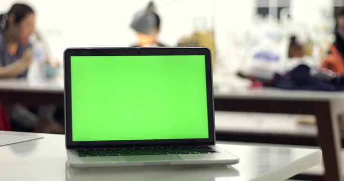 Green laptop computer screen set in front of workgroup