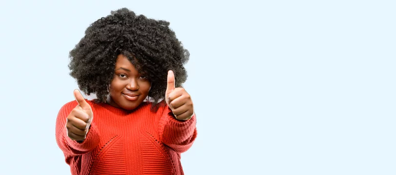 Beautiful african woman stand happy and positive with thumbs up approving  with a big smile expressing okay gesture, blue background Stock Photo |  Adobe Stock