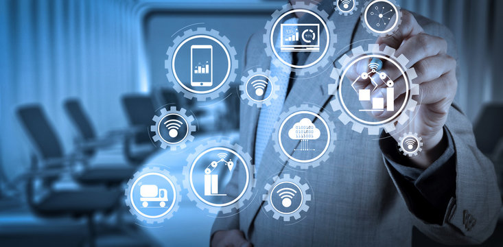 Smart factory and industry 4.0 and connected production robots exchanging data with internet of things (IoT) with cloud computing technology.businessman working with virtual computer.