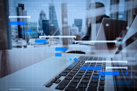 designer hand working and smart phone and laptop on wooden desk in office