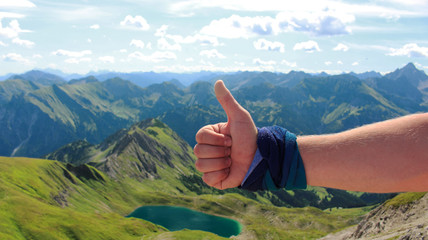 Kciuk do góry na tle panoramy niemieckich Alp. Allgau - obrazy, fototapety, plakaty