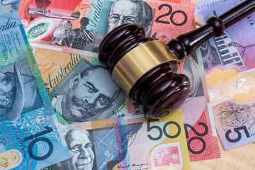 Judge's gavel on australian dollar banknotes, closeup