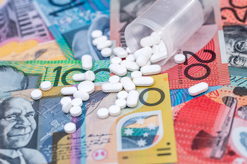 Dispersed white tablets on australian dollar banknotes