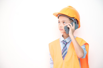 Young boy engineer isolated in white. Handsome early teenage boy portrait with engineering cloth. Talking on mobile phone.