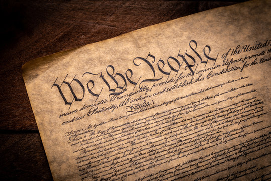 A copy of the Constitution of the United Sates of American on a wooden background
