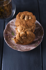 A glass with leaf tea and homemade cookies. Flowers and decor. Breakfast. Dark photo. Place for text