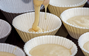 making muffins, filling the cups with batter