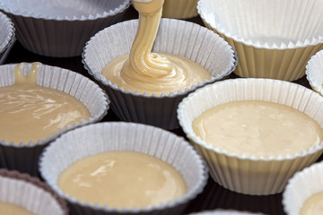 making muffins, filling the cups with batter