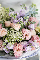 Bouquet of beautiful flowers on gray table. Floristry concept. Spring colors. the work of the florist at a flower shop. Vertical photo