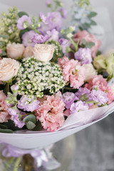 Bouquet of beautiful flowers on gray table. Floristry concept. Spring colors. the work of the florist at a flower shop. Vertical photo