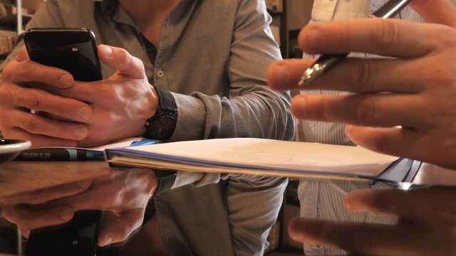 Two Business Men planning work with Pen and Paper on a Lunch in Cafe