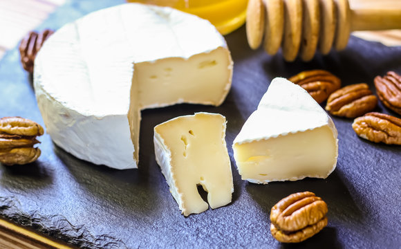 Camembert cheese on the cutboard with pecan nuts