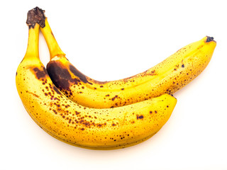 Reife Bananen mit dunklen Flecken isoliert vor weißem Hintergrund.