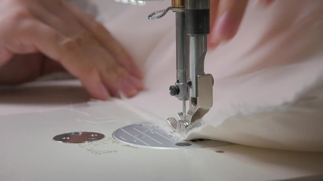 close-up of sewing machine, stitch thread seam. Equipment for sewing elegant wedding dress. Hand made