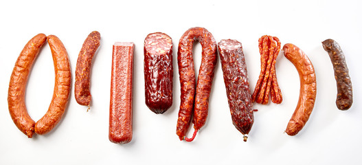 Flat lay still life of a mix of spicy sausages - obrazy, fototapety, plakaty