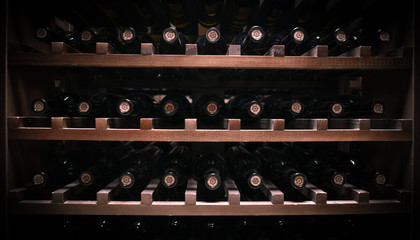 bottles of wine lie on wooden shelves