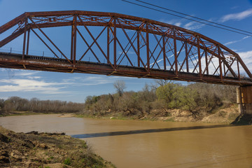 Fototapeta premium Iron Railroad Bridge over water, Texas