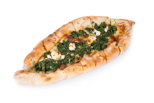 Traditional turkish pizza pide with spinach on white. Top view.