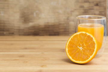 Natural orange juice with open half orange fruit on a wooden background