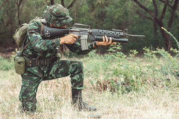 Soldier reloading his assault rifle. Chinese professional soldier reloading his weapon and putting...