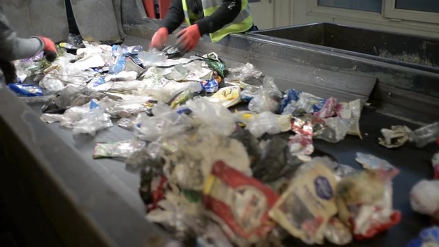Workers Hands sorting Plastic waste moving on Conveyor, Garbage sorting Station