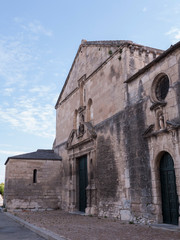 Fototapeta na wymiar old church against blue sky and white clouds, Arles, France