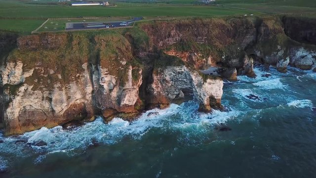 aerial view of cliffs with arch during sunset in Northern Ireland
