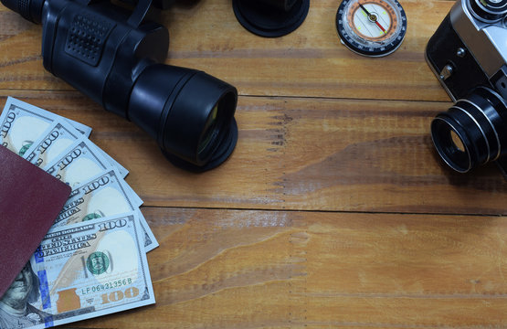 going on vacation (travel), on the table is a passport with money (dollars), glasses, camera