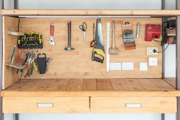 Wooden workbench at workshop. Lot of different tools for diy and repair works. Wood desk for product placement. Copyspace. Labour day - obrazy, fototapety, plakaty