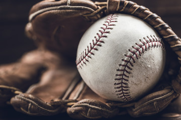 A group of vintage baseball equipment, bats, gloves, baseballs on wooden background