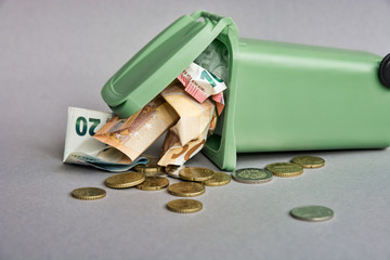 Euro money: closeup of banknotes and coins in the garbage can. 