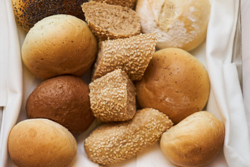 Variety of sliced bread in basket, close-up. A lot on mixed bun, top view 