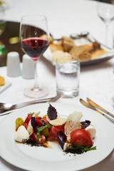 Vegetarian food with marinated tomatoes, arugula, mozzarella cheese, balsamic jelly, olive oil. Delicious healthy food concept, close-up