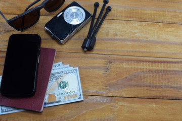 going on vacation (travel), on the table is a passport with money (dollars), glasses, camera