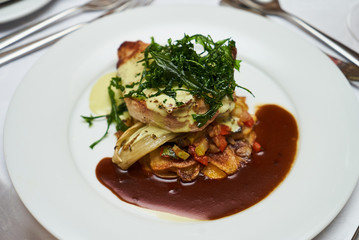 People eating roasted organic chicken dish with tarragon, mustard sauce, rosemary, potatoes tian and confit fennel, close-up. Delicious healthy food dinner on serving table concept