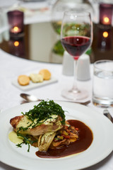 People eating roasted organic chicken dish with tarragon, mustard sauce, rosemary, potatoes tian and confit fennel, close-up. Delicious healthy food dinner on serving table concept