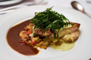 People eating roasted organic chicken dish with tarragon, mustard sauce, rosemary, potatoes tian and confit fennel, close-up. Delicious healthy food dinner on serving table concept