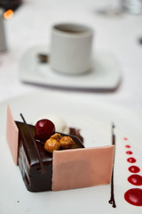 Black forest Cake with cherry, vanilla ice-cream, chocolate and cup of hot tea on table. Delicious sweet dessert breakfast on table background, close-up