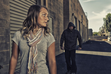 Girl who knows self defense sees a man walking behind her. - obrazy, fototapety, plakaty