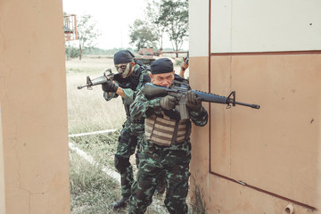 Special force soldiers in urban combat training.  Breach and entry building. Chinese soldiers in full combat gear, green digital cammo.