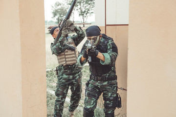 Special force soldiers in urban combat training.  Breach and entry building. Chinese soldiers in full combat gear, green digital cammo.