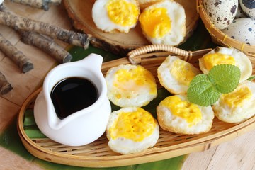 Grilled eggs with sauce on wood background
