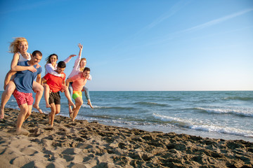 Friends fun on the beach under sunset sunlight