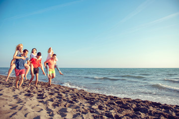 Friends fun on the beach under sunset sunlight