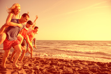 Friends fun on the beach under sunset sunlight