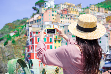 Fototapeta premium Young woman taking selfie background beautiful old italian village, Cinque Terre, Liguria