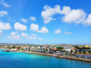 Naklejka na ściany i meble aerial view of the coastline city of Kralendijk, capital of Bonaire, with colorful buildings and blue sea and sky.
