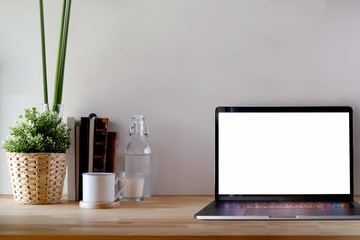 Mockup white screen laptop on table. workspace with blank screen laptop computer for graphic display montage